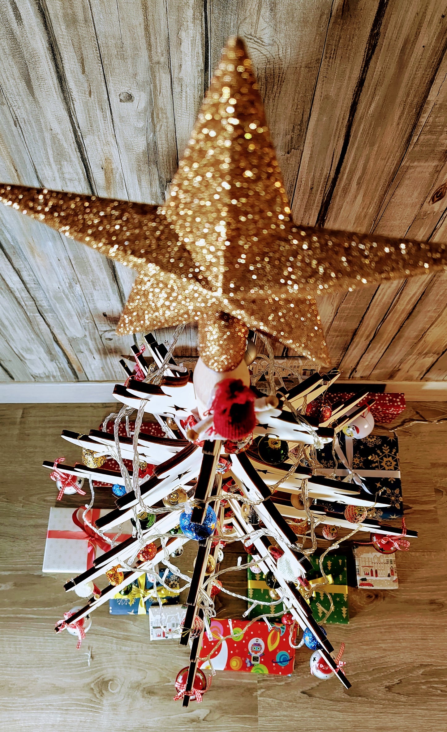 Top down view of 3 foot modular wooden Christmas tree decorated with baubles, lights and a star. 